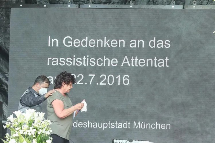 Gedenkveranstaltung zum rassistischen Attentat am 22.7.2016 in München, mit Teilnehmern, die Blumen niederlegen.